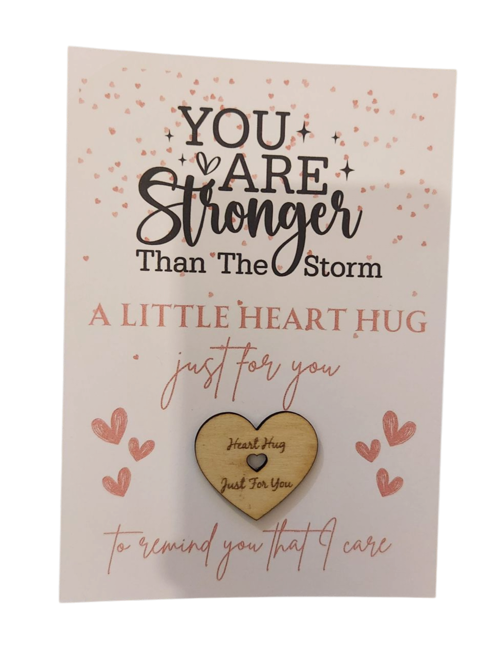 Card with motivational message and wooden heart charm on a beige background